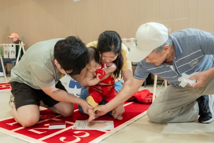 「抓周」是華人傳統育兒文化中的一種周歲儀式，通常在寶寶滿一歲時舉行。家長會在孩子面前擺放各種具有象徵意義的物品，讓孩子自由抓取，藉此象徵孩子未來的興趣、個性或發展方向，也代表家人對孩子成長的祝福與期待。  常見抓周物品例如：  書本：象徵聰明、愛讀書 算盤／錢幣：象徵財富、理財能力 麥克風：象徵表達能力、表演天分 畫筆：象徵藝術創作 醫療器具：象徵醫護相關志向 球類：象徵運動天分  現代的抓周活動，除了保留傳統文化意義，也結合親子互動、拍照紀念與家庭儀式感，因此成為許多年輕家庭喜愛的重要成長活動之一。